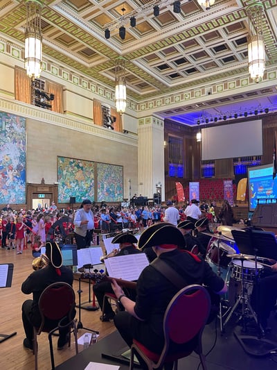 The big band are conducted by Geoffrey Pearce, as children play the pBuzz.