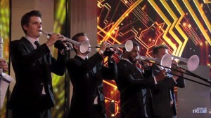 Black and white pTrumpet and pBones being played by a brass band during Britain's Got Talent, 2016.
