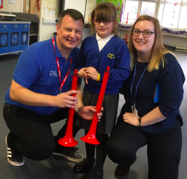 Darren Lea from Warwick Music Group with a pupil and year two teacher.