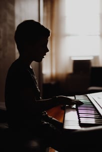 A child playing a digital piano at home.