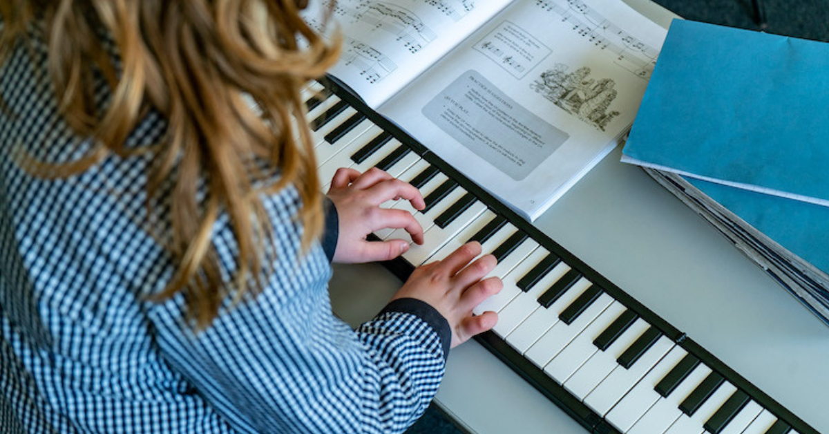 A child playing a digital piano in the classroom.